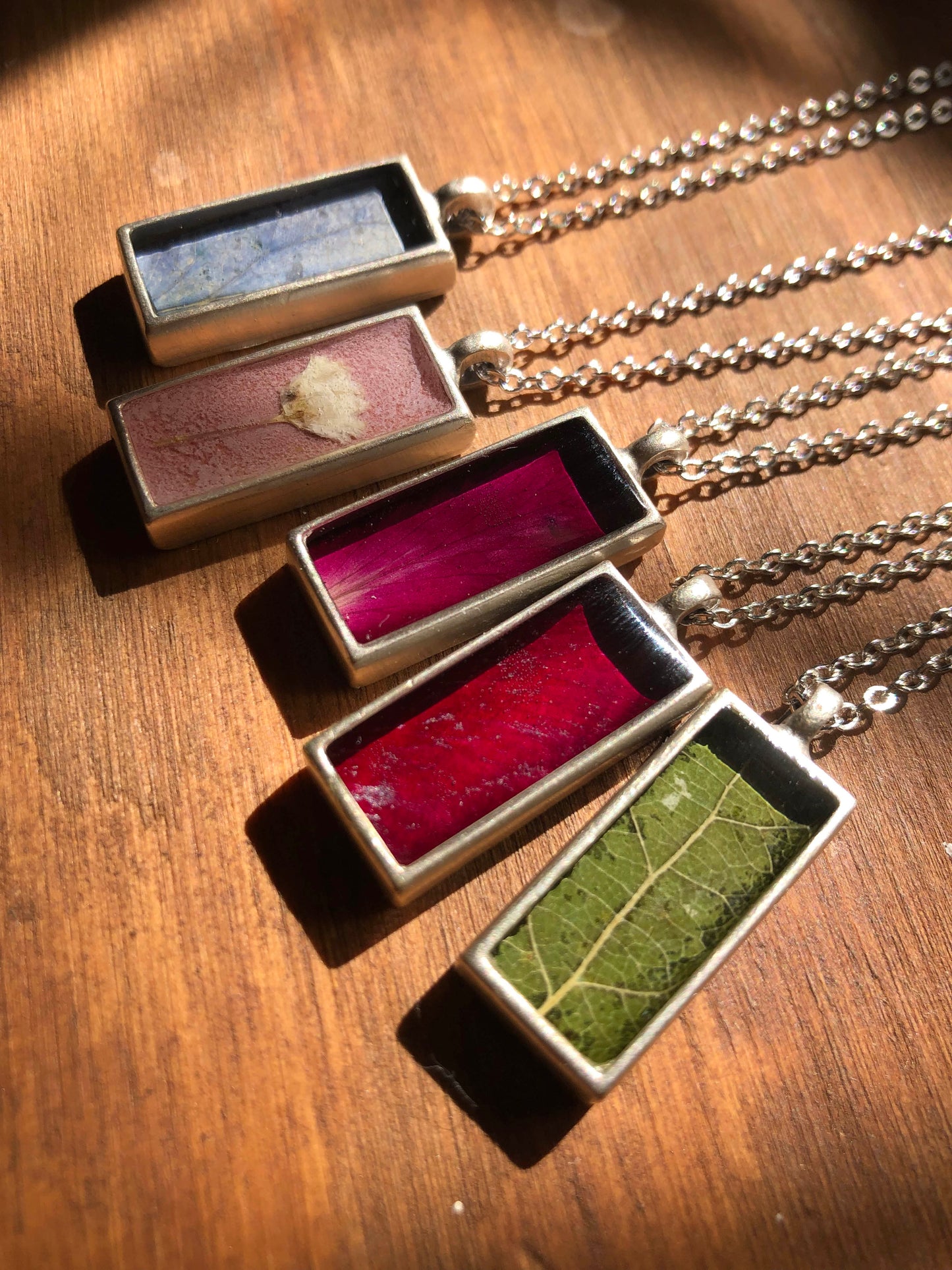 Rektangulära halsband gjorda med färgglada blommor och löv