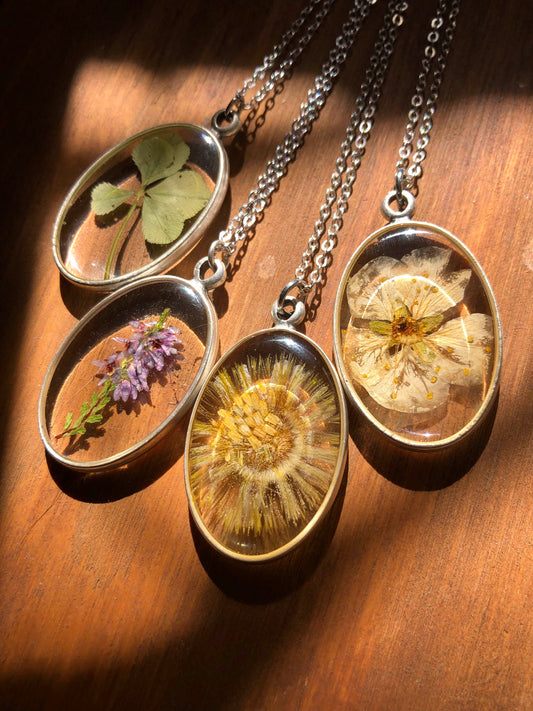 Oval pendant with real five-leaf clover, heather, coltsfoot & apple blossom