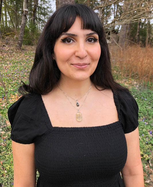 Black teardrop pendant with a tiny shell.