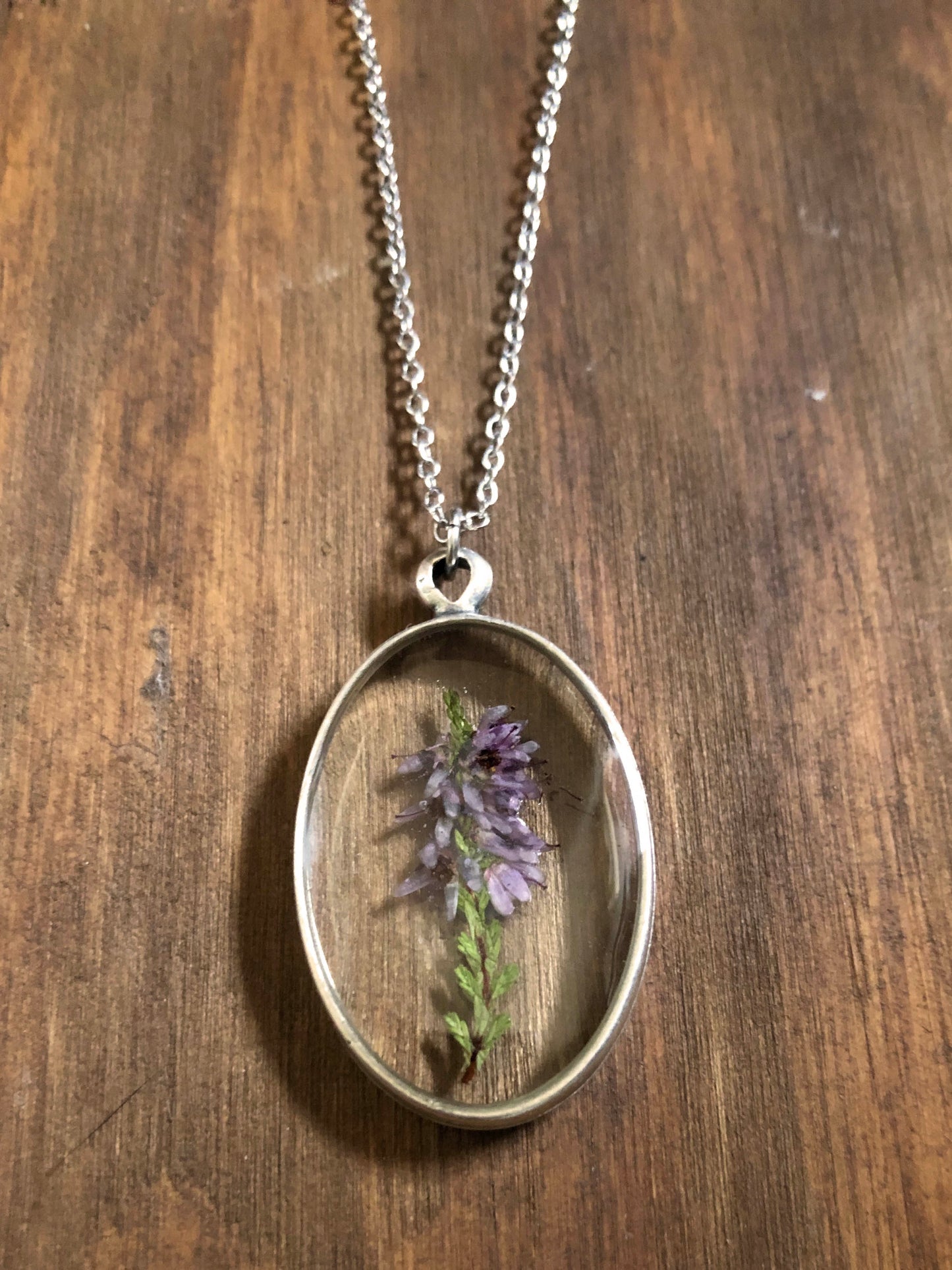 Oval pendant with real five-leaf clover, heather, coltsfoot & apple blossom